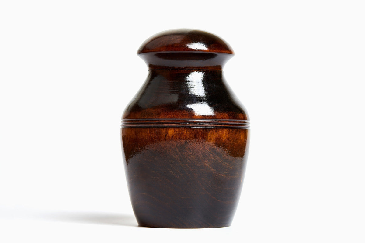 Polished dark wooden urn against a white background.