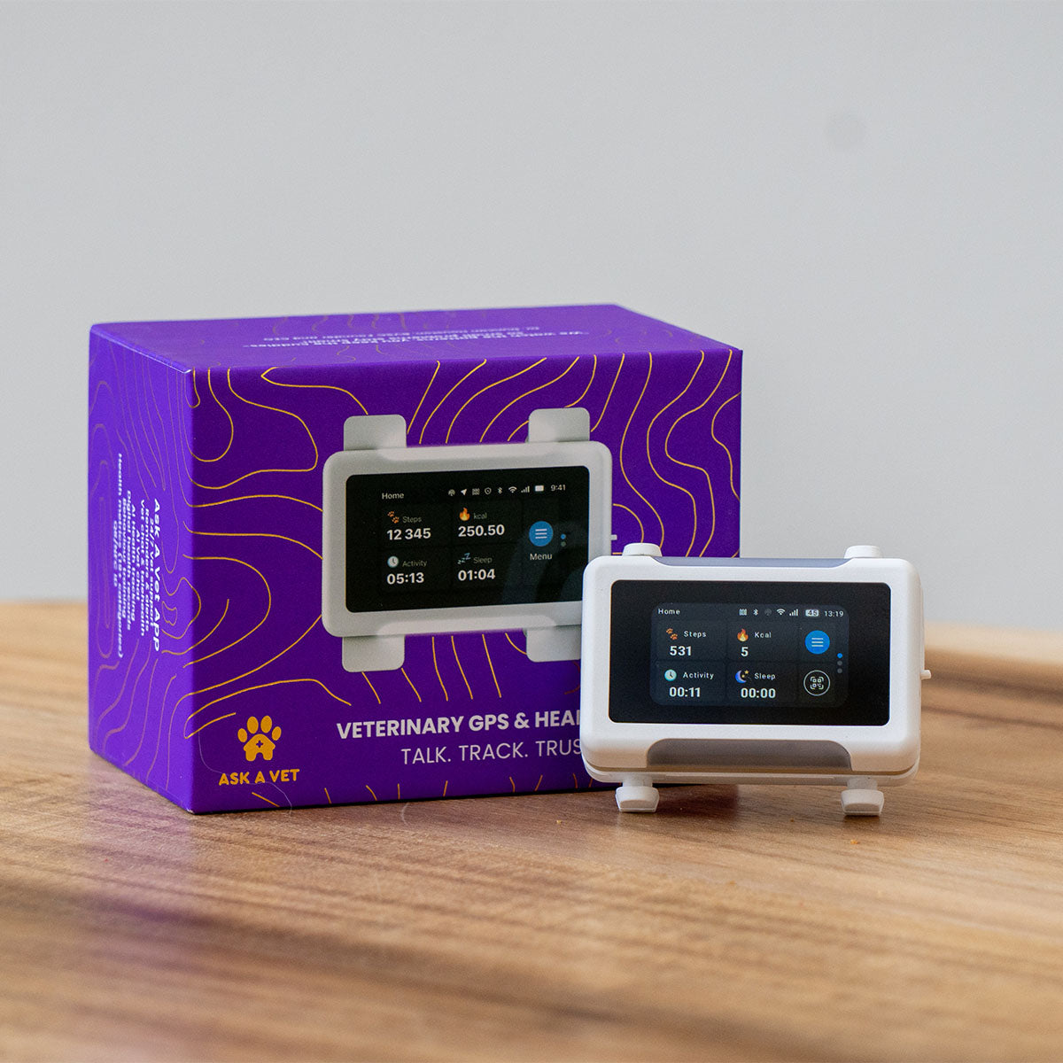 White / Gold | Smart GPS & Health Tracker: The White / Gold tracker beside its purple box on a table